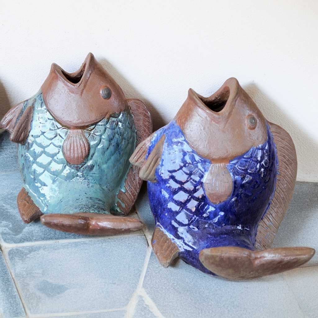 Turquoise and blue ceramic fish statues with brown accents, featuring open mouths and detailed scale textures