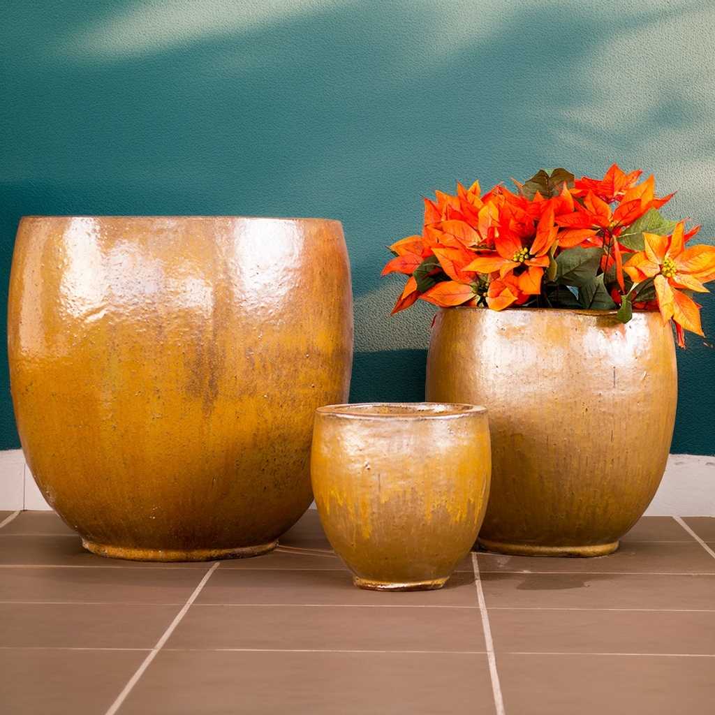 Round ceramic bulbous planters in a vibrant orange glaze, featuring a smooth and curved shape