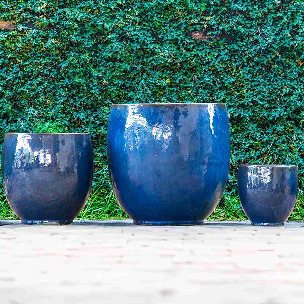 Glossy blue round ceramic bulbous planters with a smooth, curved silhouette and vibrant finish