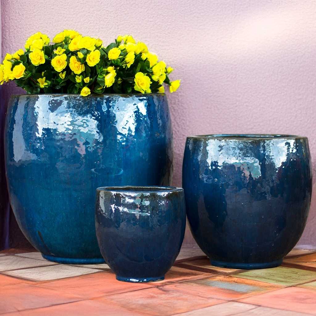 Glossy deep blue round ceramic bulbous planters with a smooth finish and full, rounded silhouette