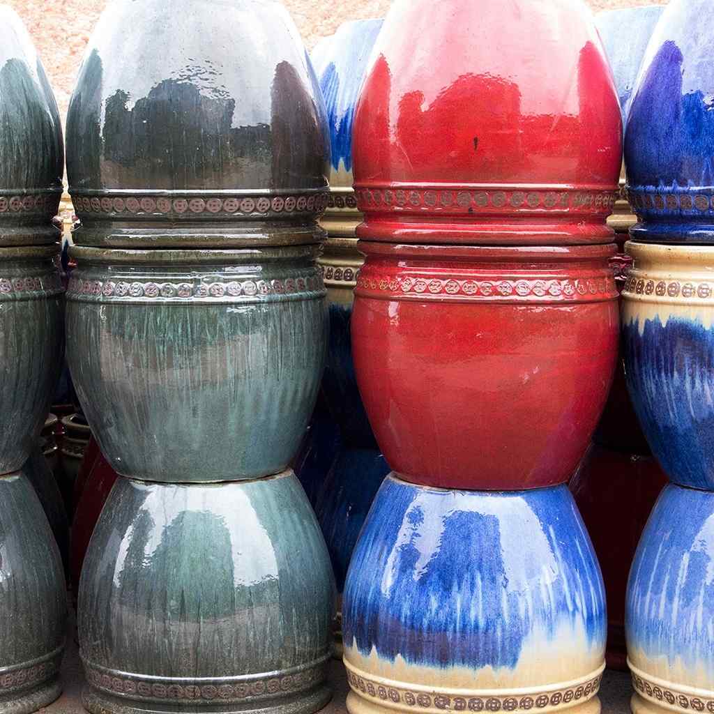 Set of 3 wide round ceramic planters in greenish, red, and blue glazes, featuring flared rims and detailed embossed banding