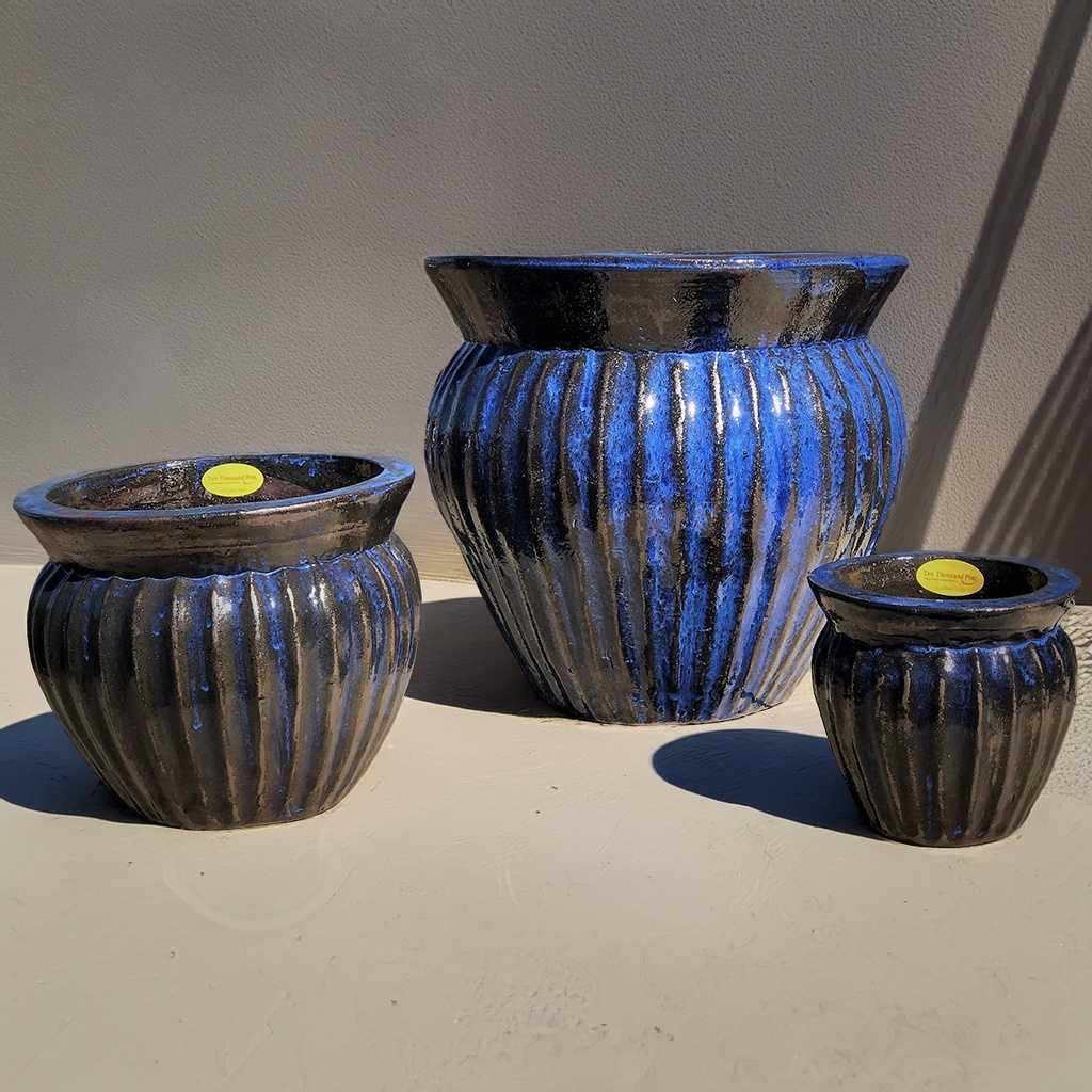 Wide round ceramic planter in rustic blue-black with vertical fluted texture for added depth and character