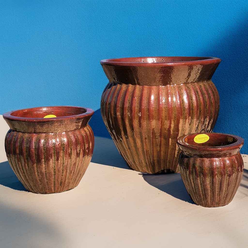 Wide round ceramic planter in rustic reddish-brown, featuring vertical fluting for added texture and classic charm