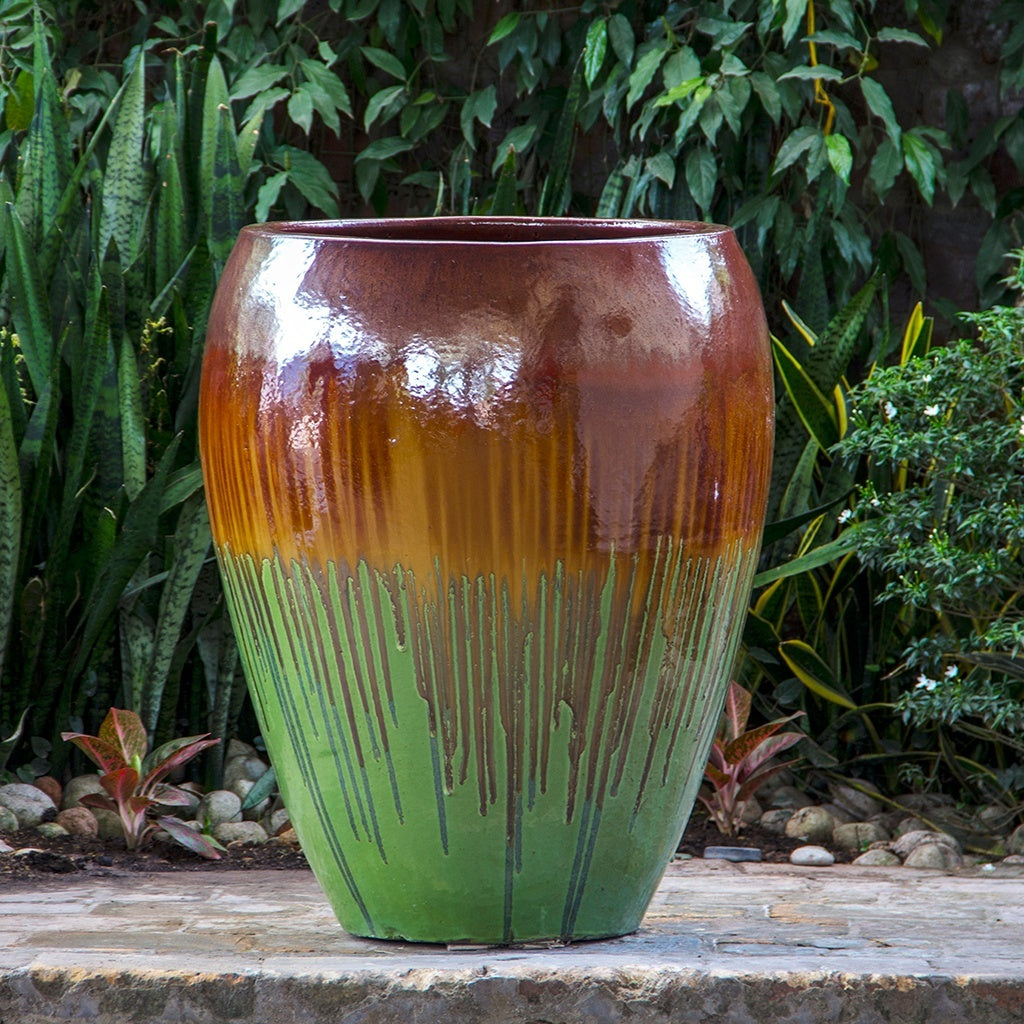 Glazed egg-shaped planter in green and brown with drip-like patterns