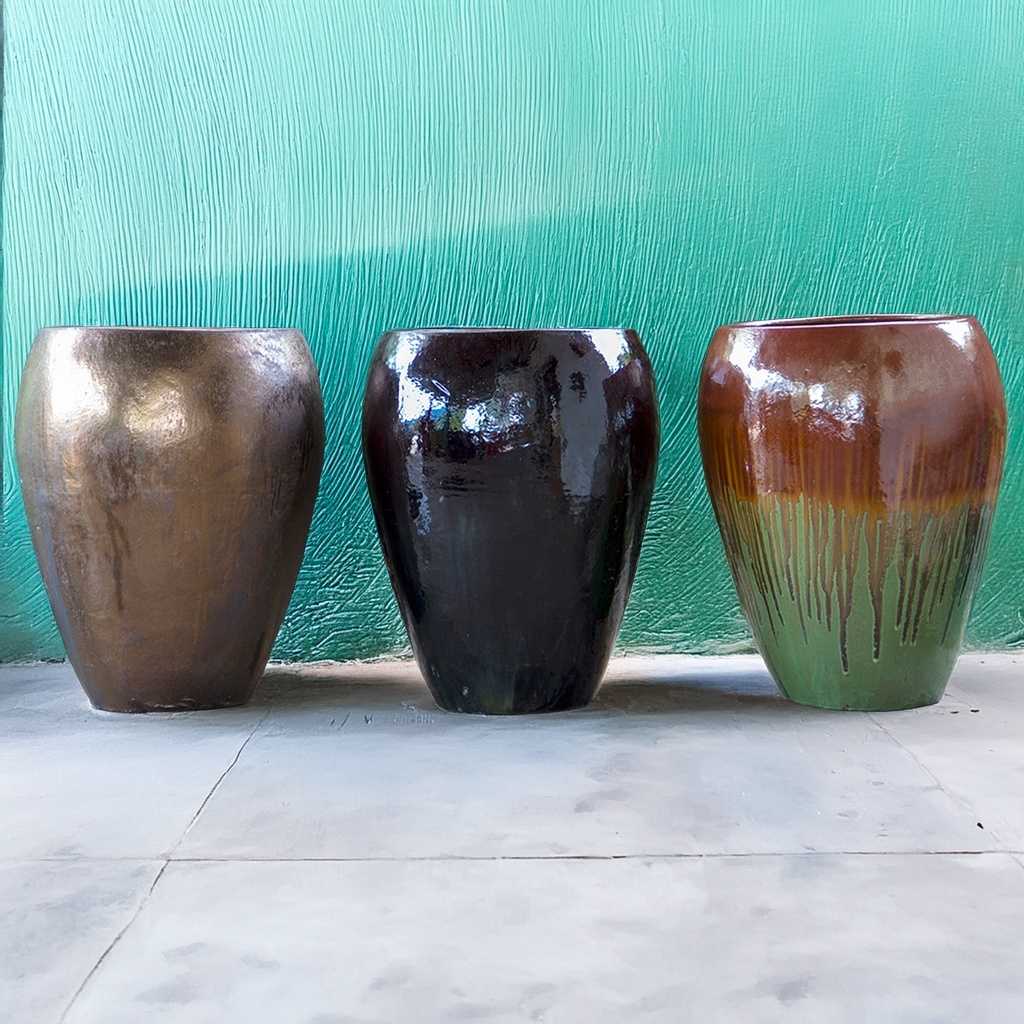 Egg-shaped planters in metallic brown, glossy black and green with brown drip glaze effect