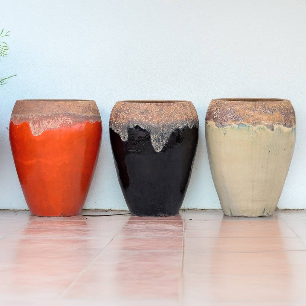 Egg-shaped planters in orange, black and cream with textured drip-like rim