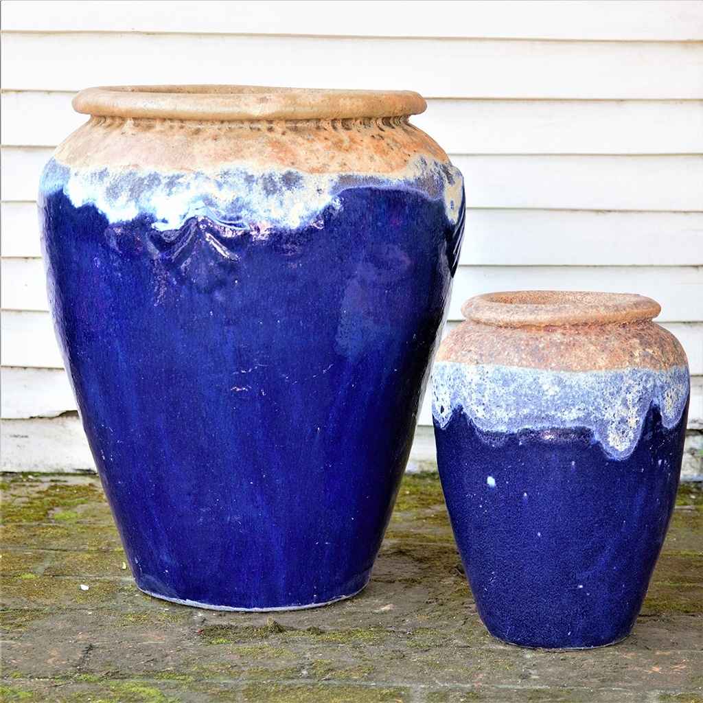 Tall, rounded jar-style planters in glossy dark blue featuring a textured rim and a distinctive dripping glaze effect
