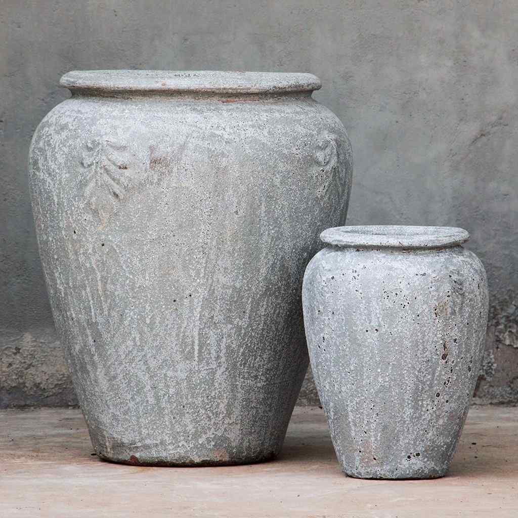 Tall, rounded jar-style planters in weathered light gray