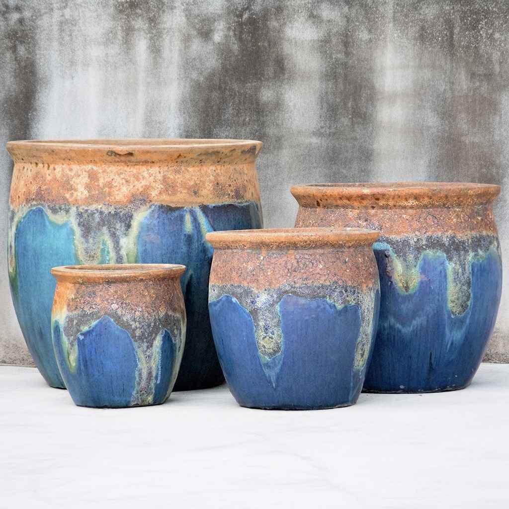 Rustic rounded ceramic planter with a glazed blue body and a textured, natural-finish top