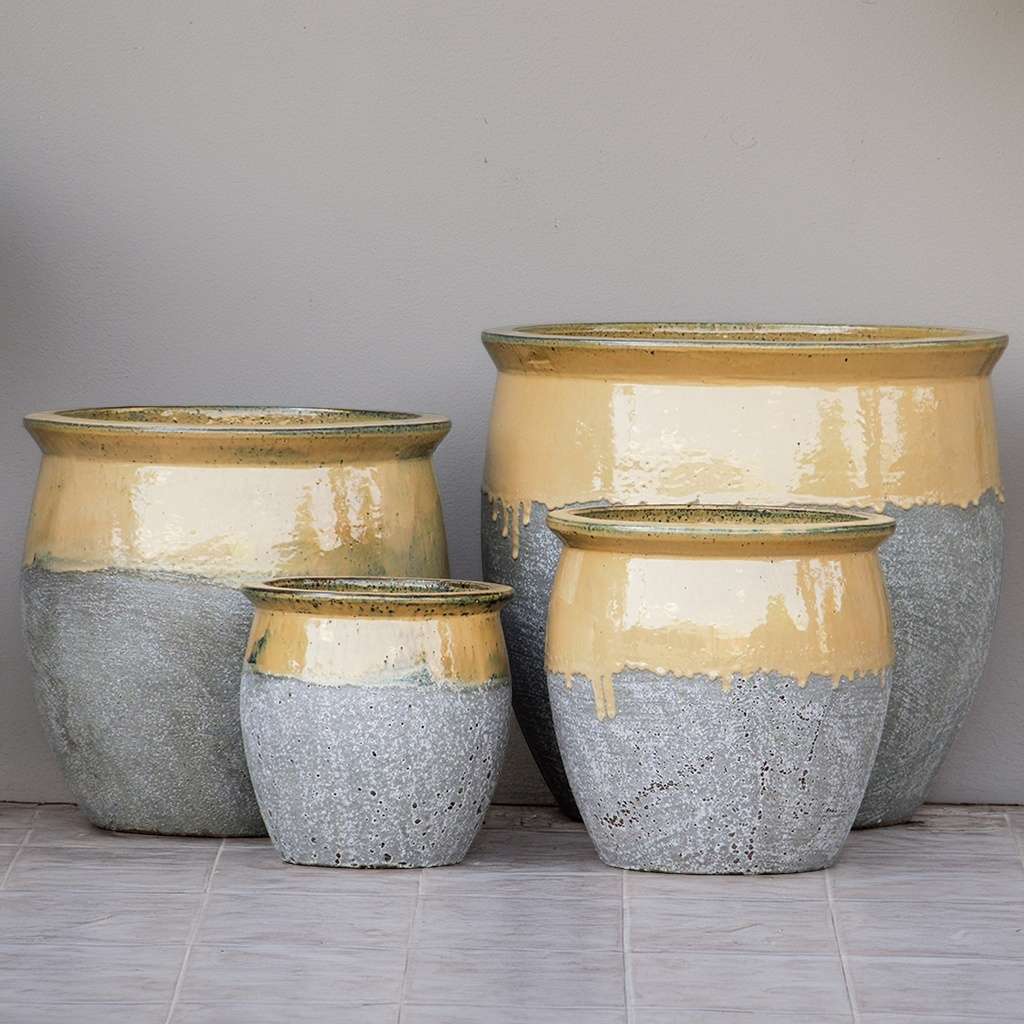 Rounded ceramic planter with a textured gray body and a glossy beige top