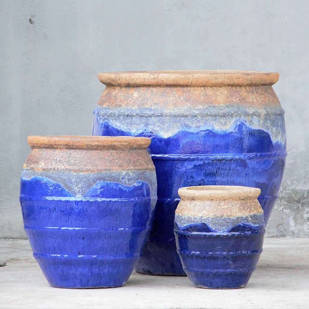 Rounded ceramic planters in blue featuring a rustic brown drip rim and rope-texture accents