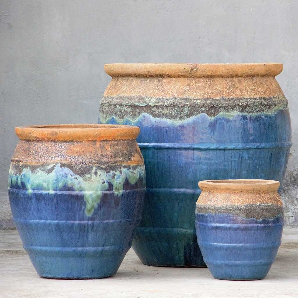 Rounded ceramic planters in blue featuring a rustic brown drip rim and rope-texture accents