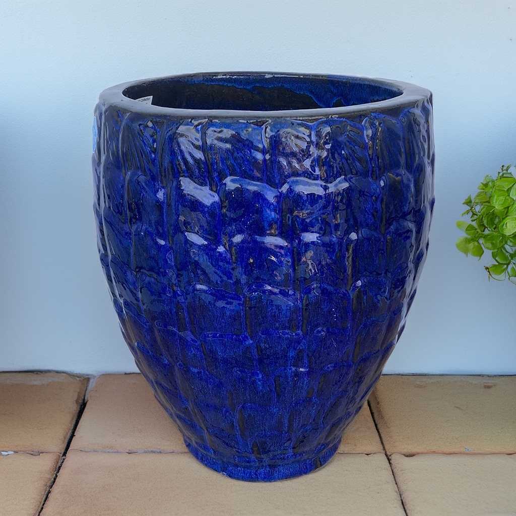 Glossy blue ceramic garden pot with a textured scallop pattern