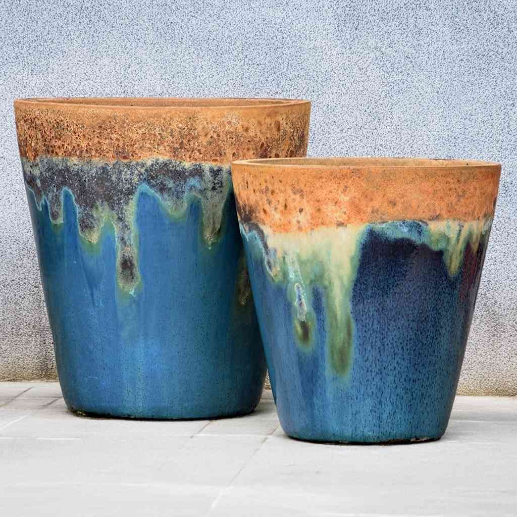 Tapered cylinder planter pots in blue with a distressed brown finish wide mouth, combining rustic texture with rich, earthy tones