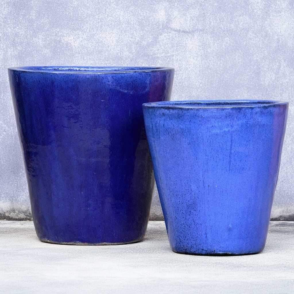 Tapered cylinder planter pots in glossy blue with a wide mouth, offering a sleek and modern look for indoor or outdoor spaces