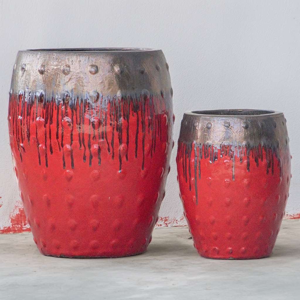 Barrel-shaped planters in red featuring a metallic bronze dripping effect and raised dot texture