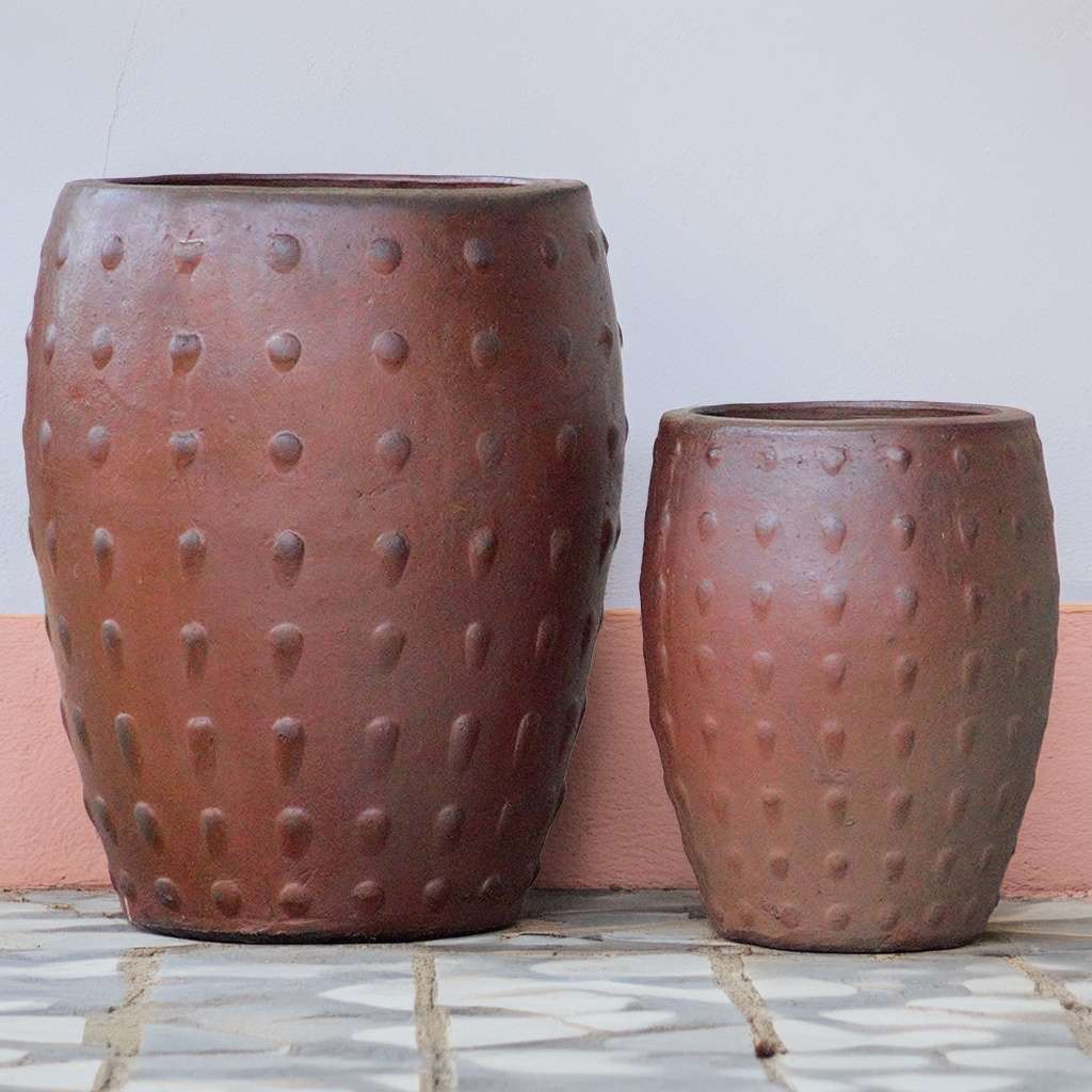 Barrel-shaped planters in rustic brown featuring a raised dot texture