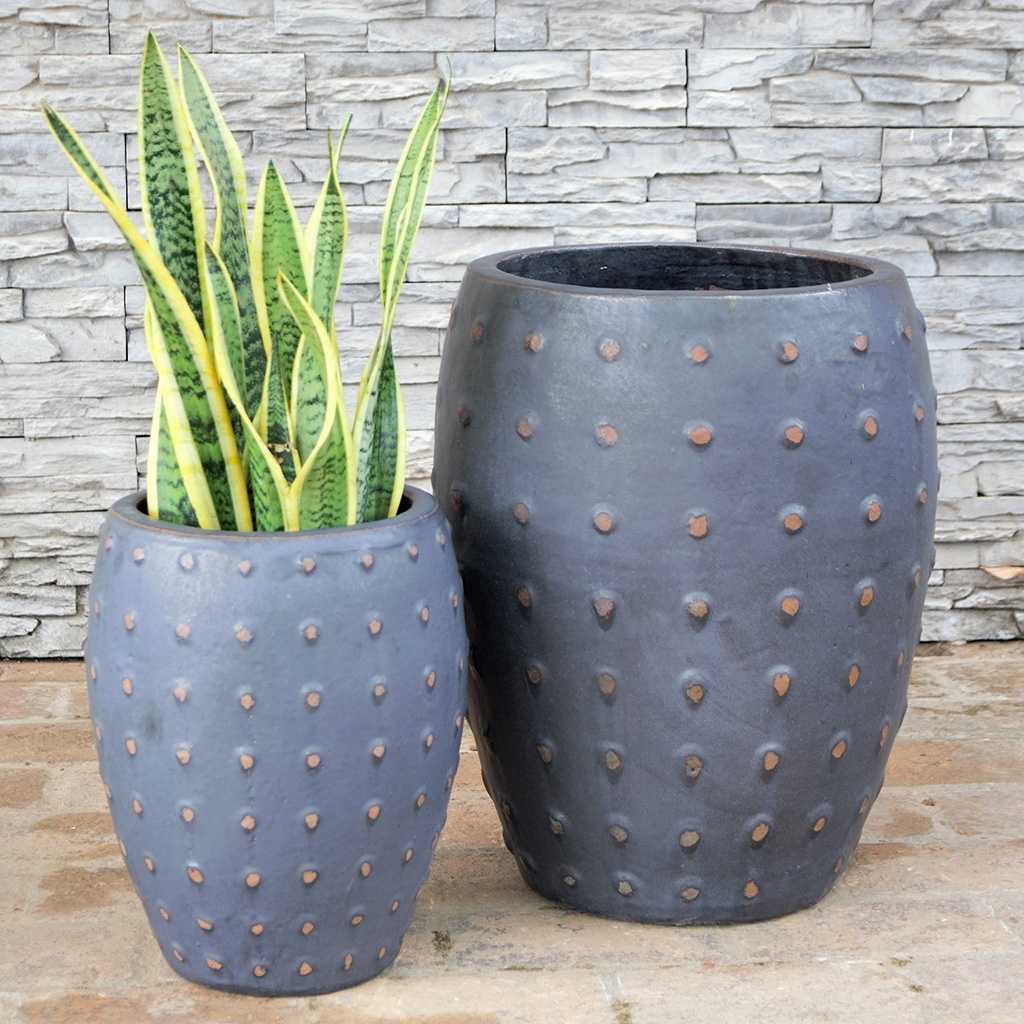 Barrel-shaped planters in matte black featuring a raised brown dot texture