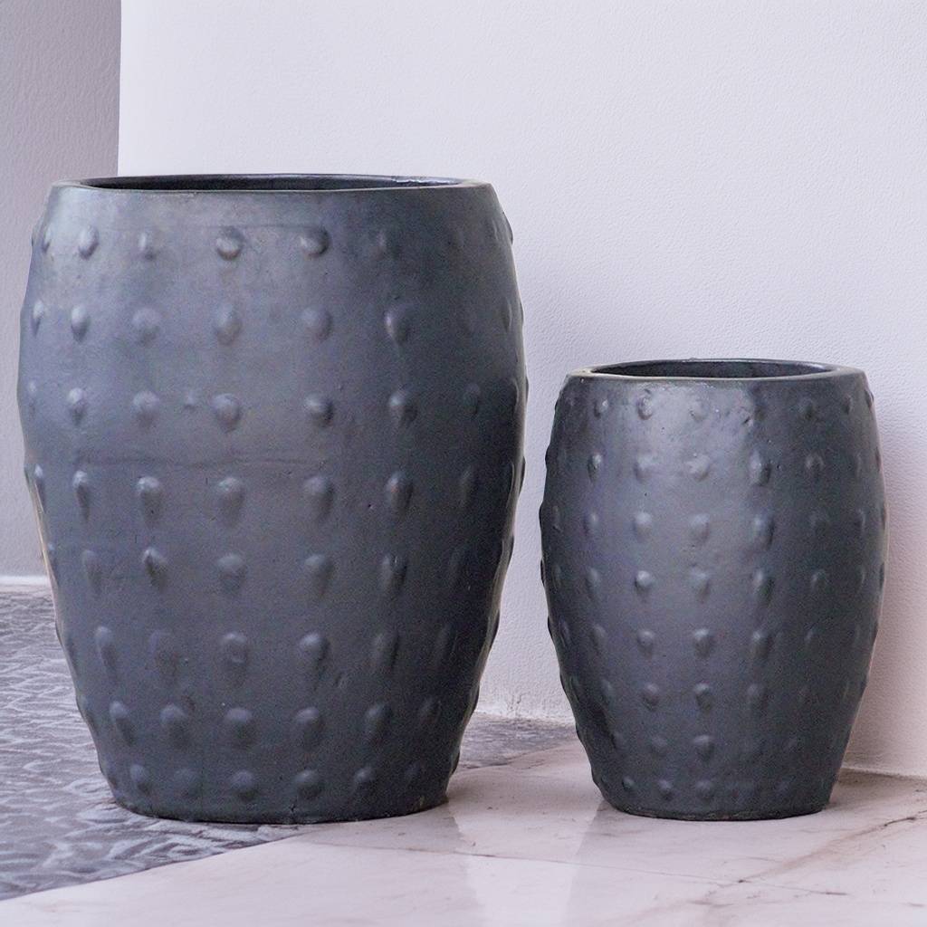 Barrel-shaped planters in matte black featuring a raised dot texture