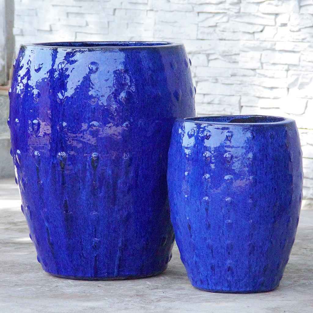 Barrel-shaped planters in glazed blue featuring a raised dot texture