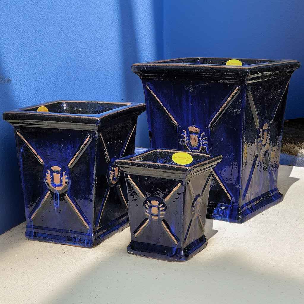 Wholesale set of 3 Glossy blue-black square ceramic planters with a flared rim and embossed regal motif