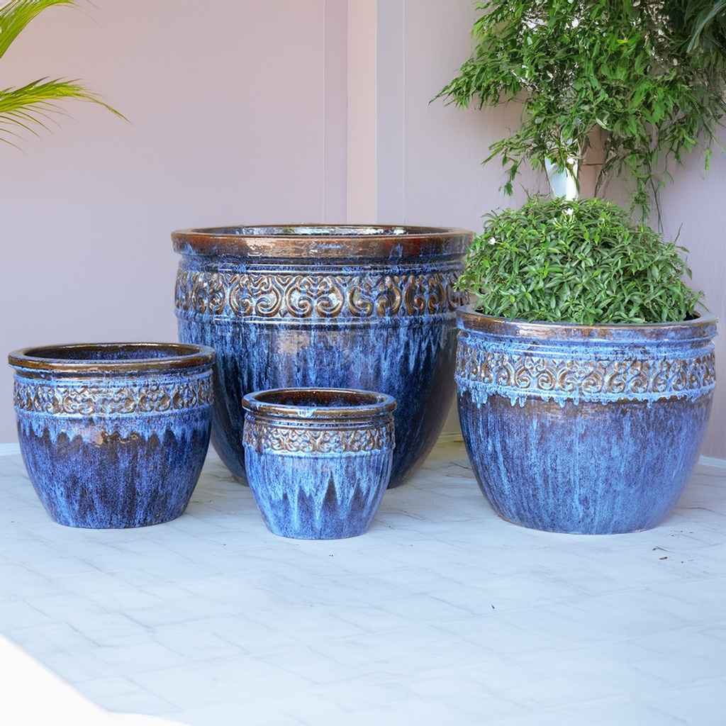 Wide-mouth ceramic planters in rustic blue with brown accents and a decorative textured rim for a charming, handcrafted look