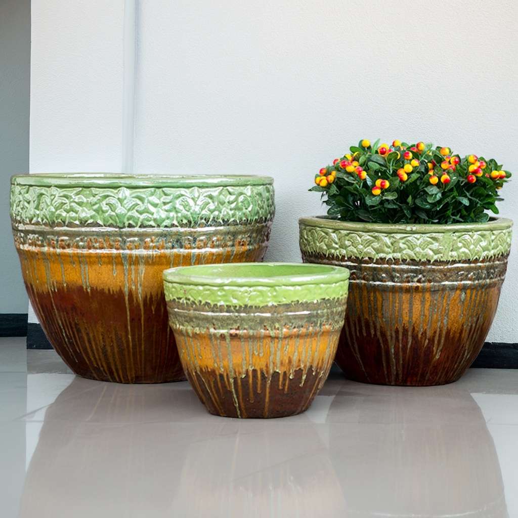 Multi-toned round ceramic planters featuring a drip-glazed effect in green, orange, and brown, with embossed floral rims