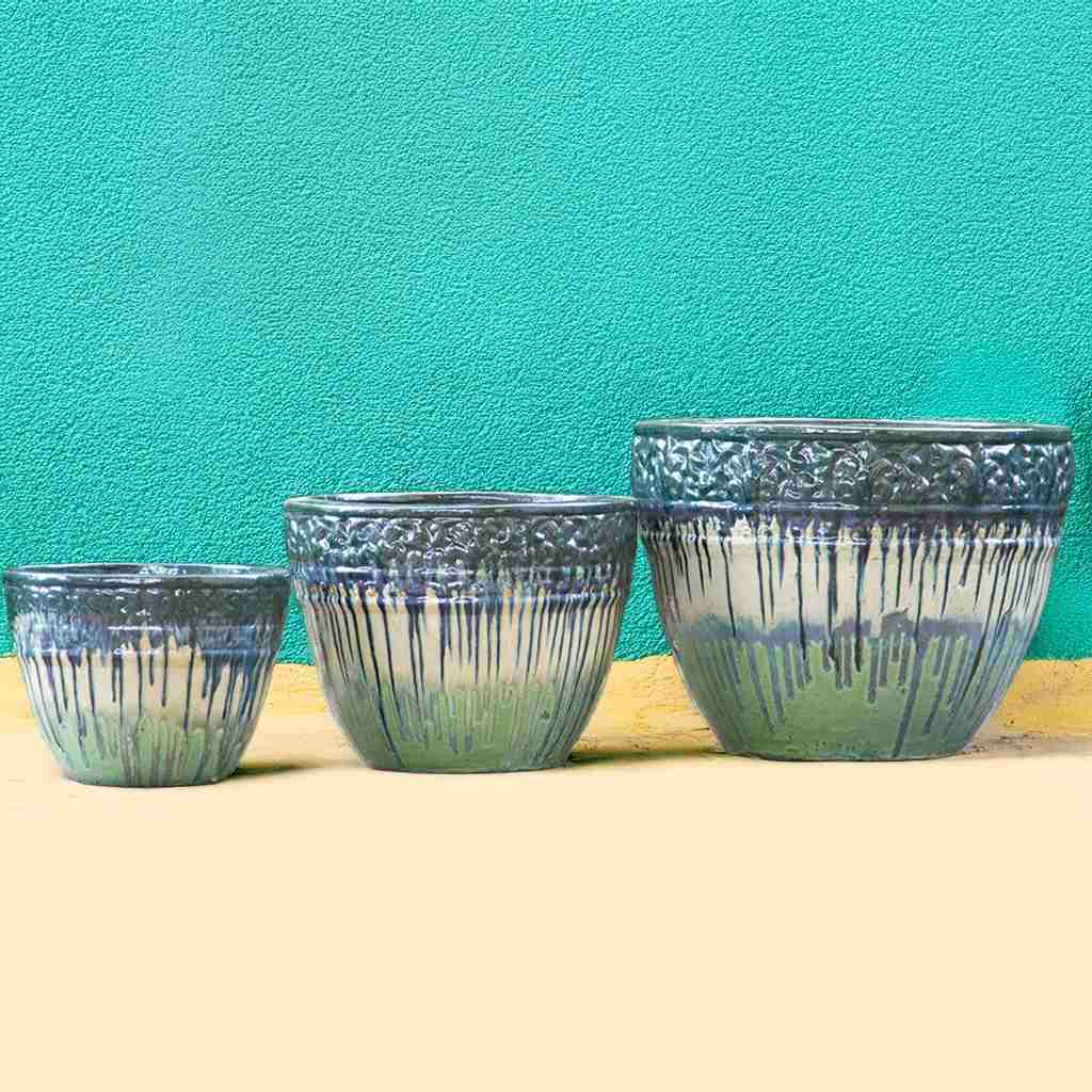 Round ceramic planters with a drip-glazed effect in green, cream, and light green, featuring embossed floral rims