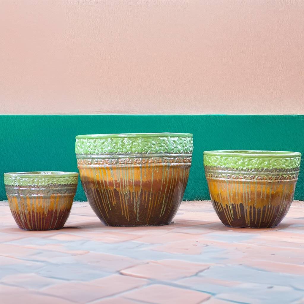 Round ceramic planters with a drip-glazed effect in light green, orange, and brown, featuring embossed floral rims