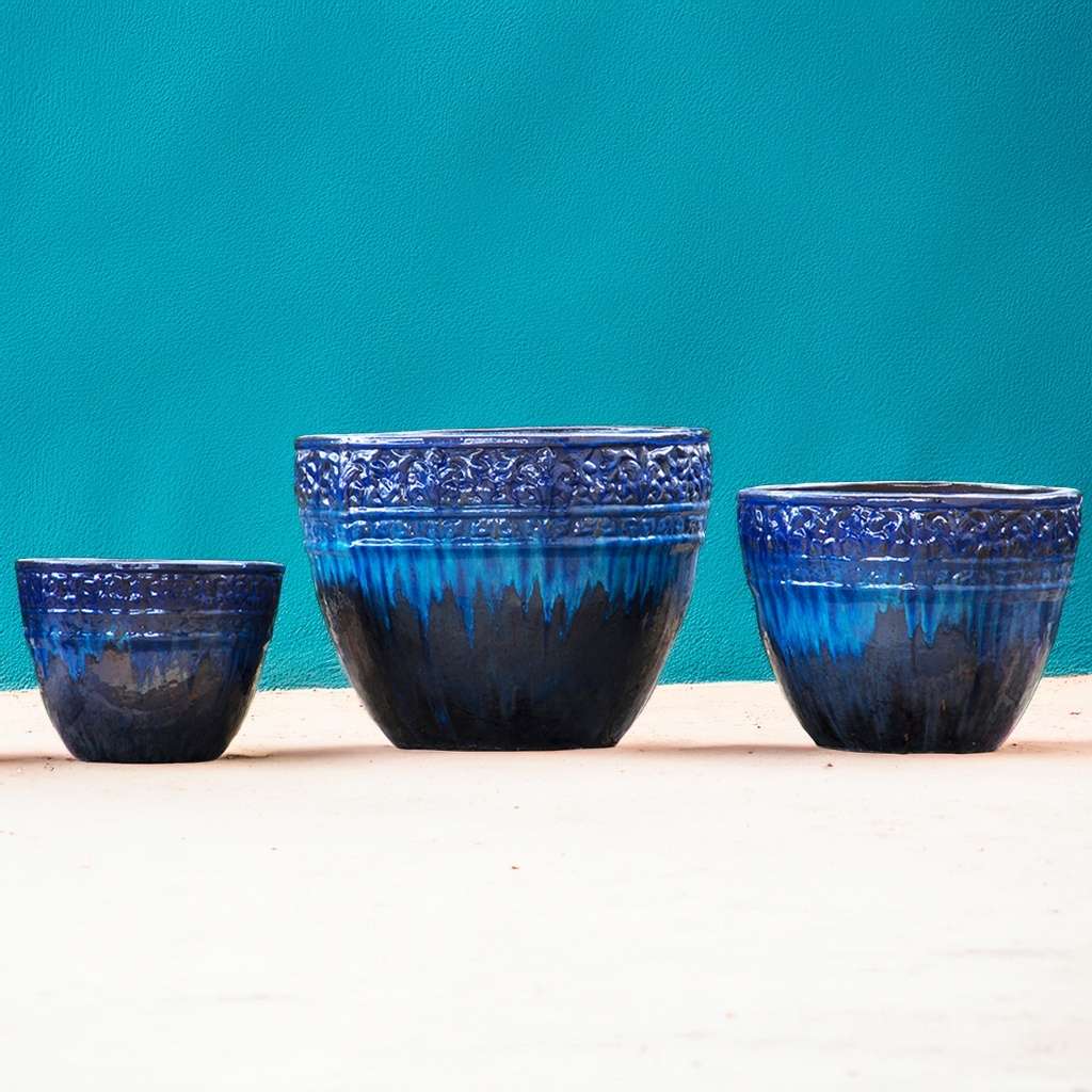Round ceramic planters with a drip-glazed effect in shades of blue and embossed floral rims