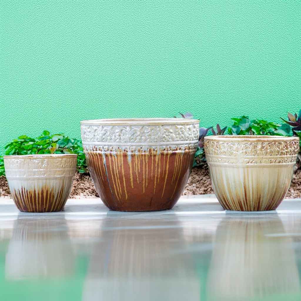 Round ceramic planters with a drip-glazed brown and cream finish, featuring embossed floral rims