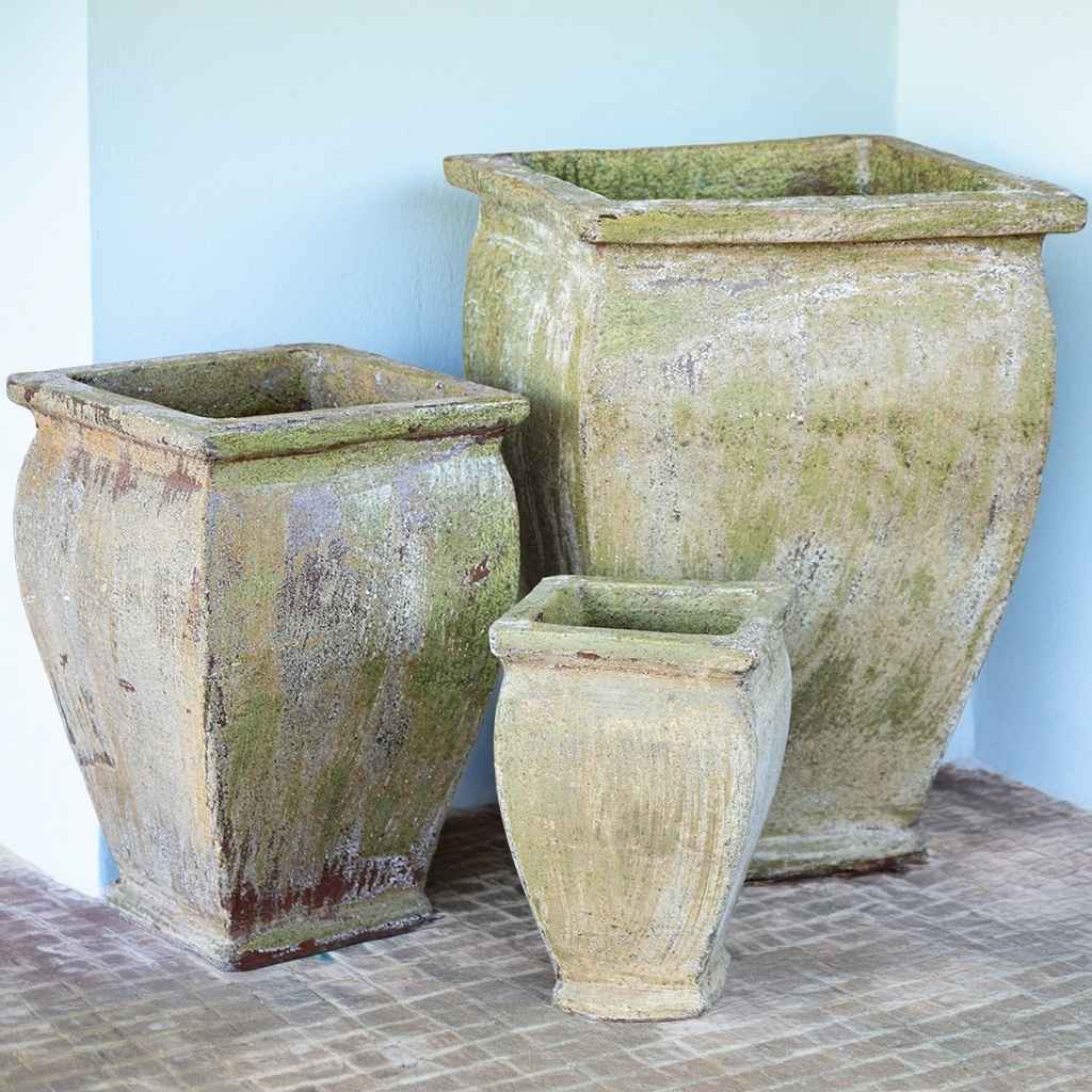 Flared square-rimmed ceramic planter in faded mossy green with a distressed finish, showcasing a weathered, aged character
