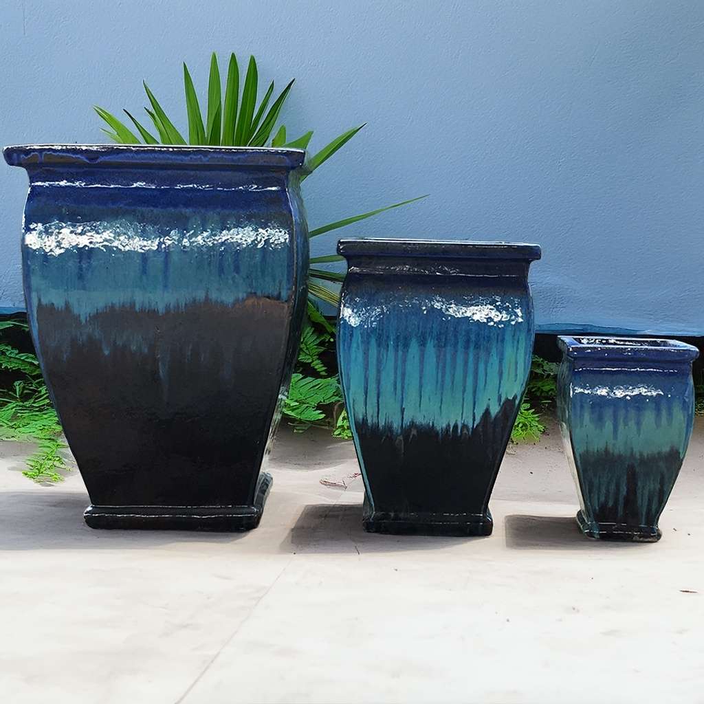 Flared square-rimmed ceramic planter with a glossy ombre finish blending black, deep blue-green, and hints of lighter blue for a dynamic, elegant look