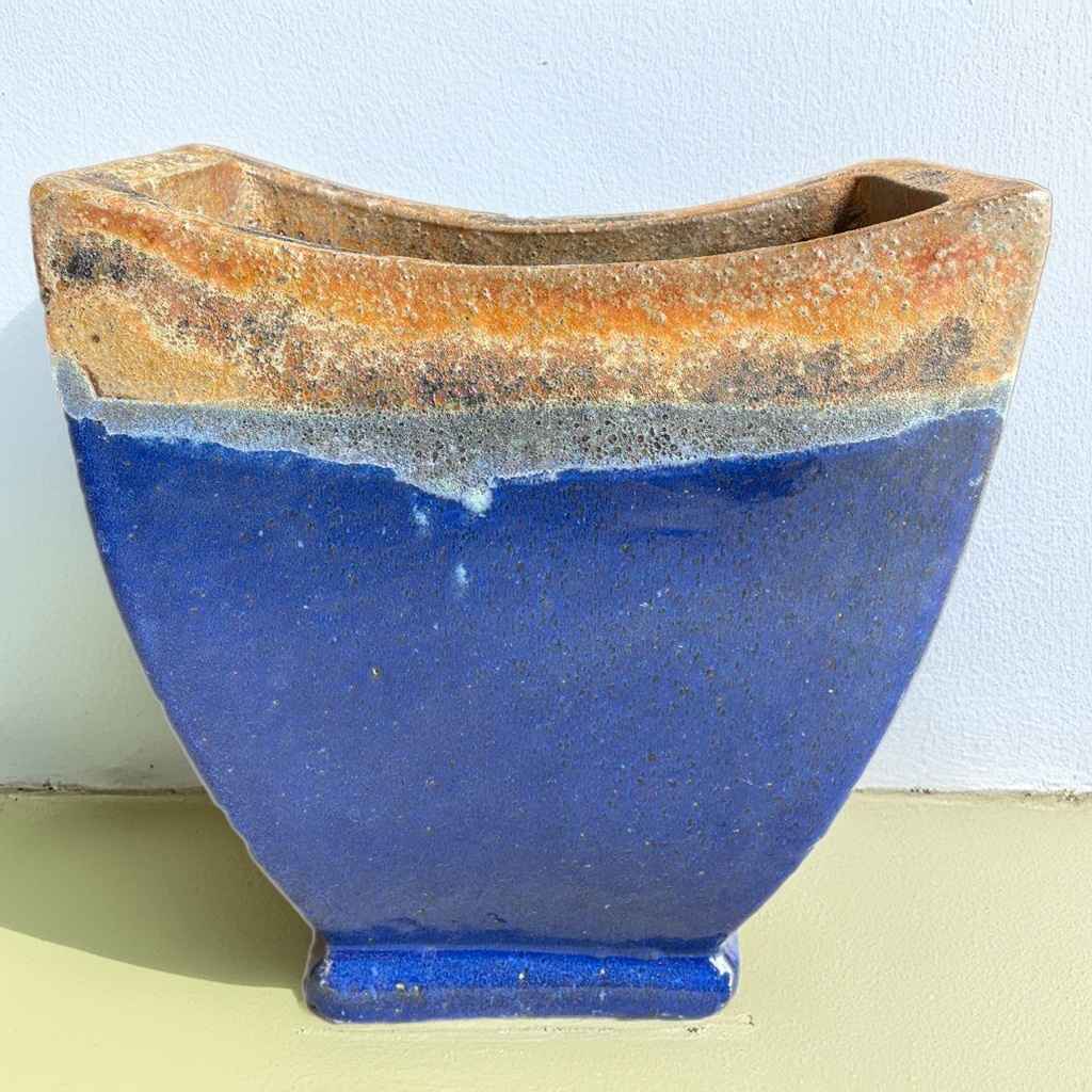 Angkor curved planters in blue with a volcanic-textured rim in orange and brown for a bold, natural contrast