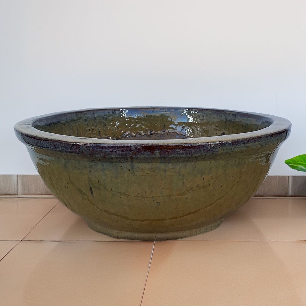 Wide low bowl planter with a glazed muted earthy green finish and subtle brown undertones