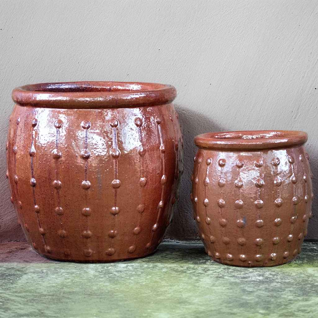 Rounded ceramic planters in copper red featuring vertical dotted ridges