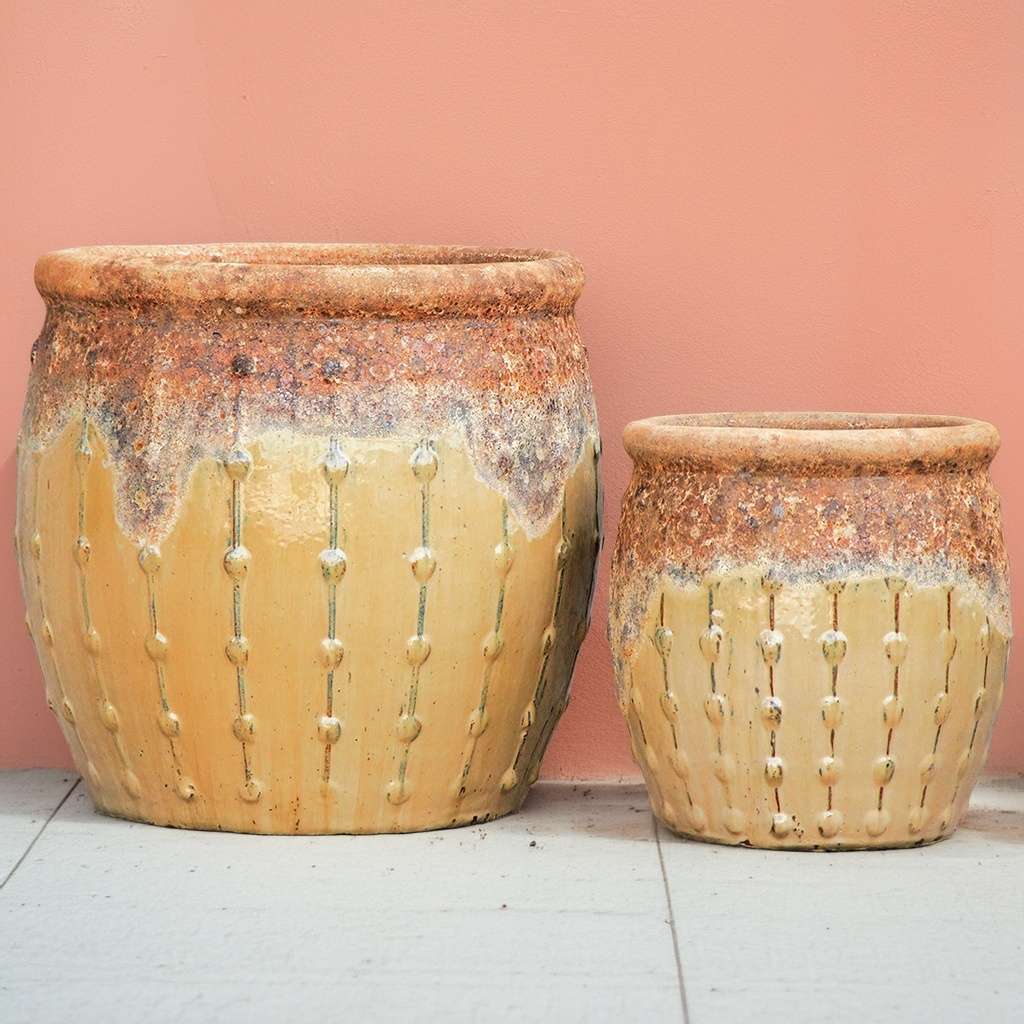 Rounded orange planters with a textured top, dripping glaze effect, and vertical dotted ridges