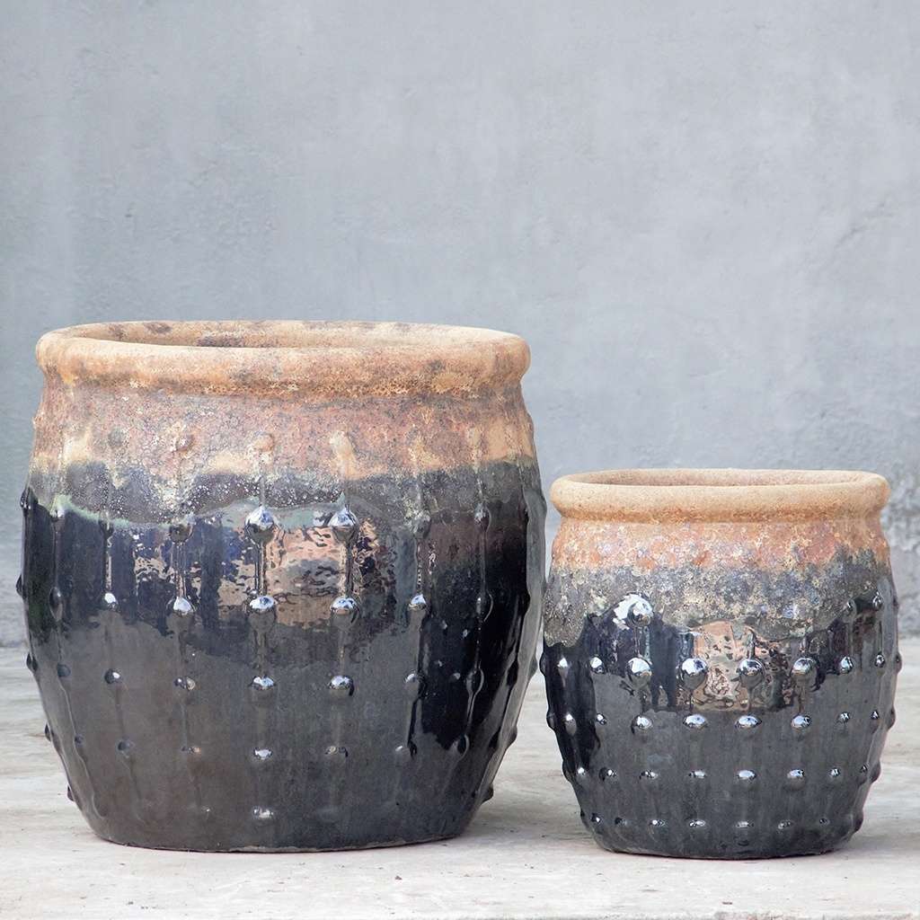Rounded planters in glossy black with a textured top, dripping glaze effect, and vertical dotted ridges