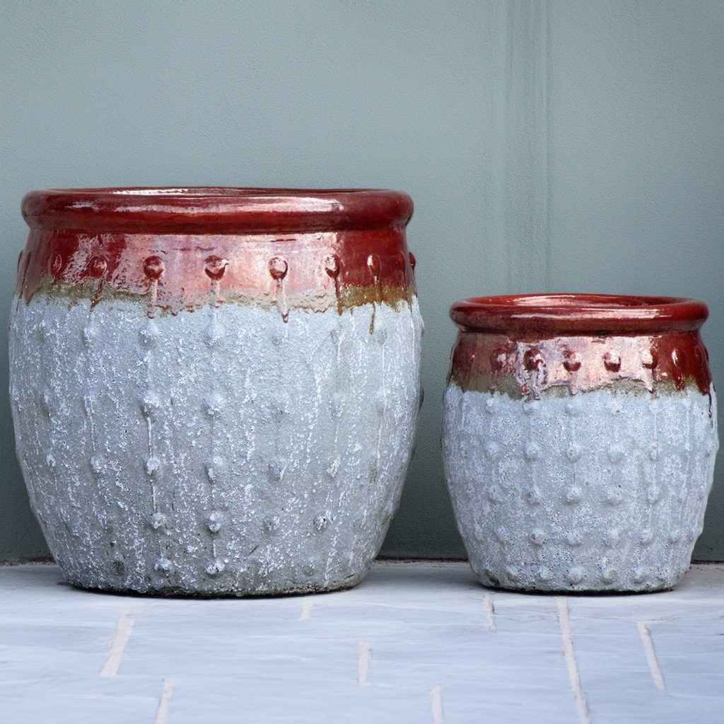 Rounded ceramic planters with a textured grey body, glossy red top, and vertical dotted ridges
