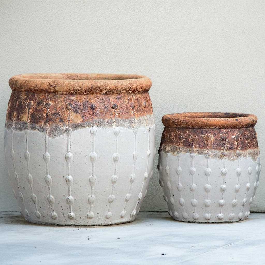 Rounded matte white planters featuring a textured top with a dripping effect and vertical dotted ridges