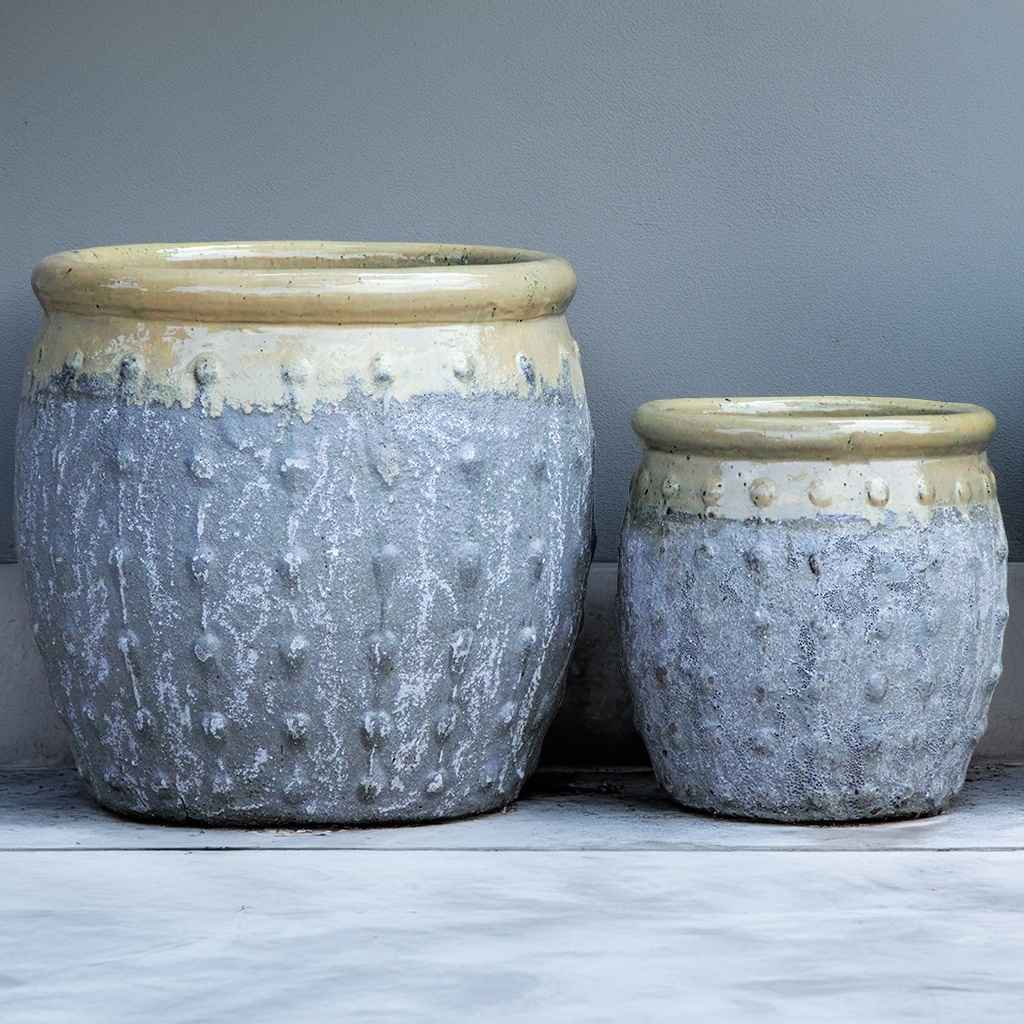 Rounded ceramic planters with textured grey body, glossy cream  top, and vertical dotted ridges