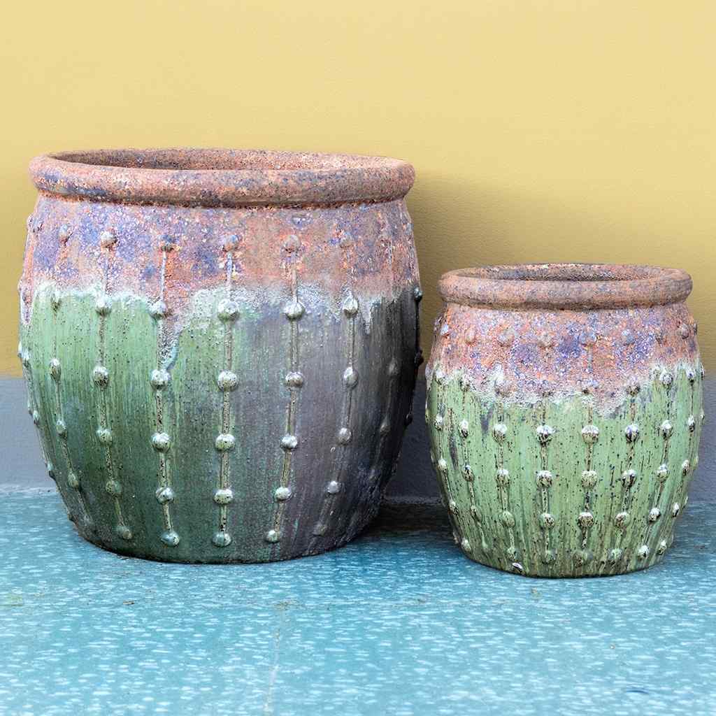 Rounded ceramic planters in rustic green featuring a textured top, dripping glaze effect, and vertical dotted ridges