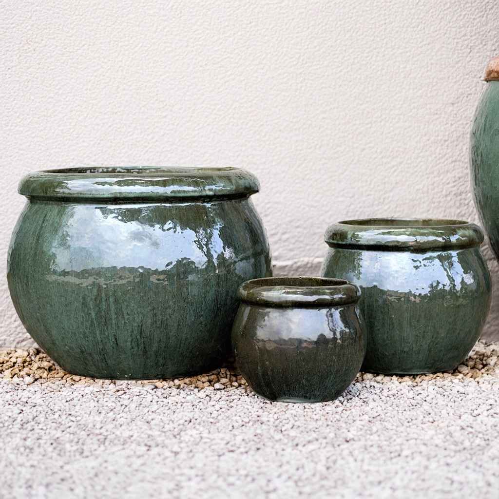 Round ceramic planters with a glossy moss green finish