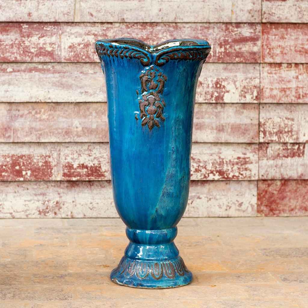 Glossy blue pedestal vase planter featuring an embossed flower design
