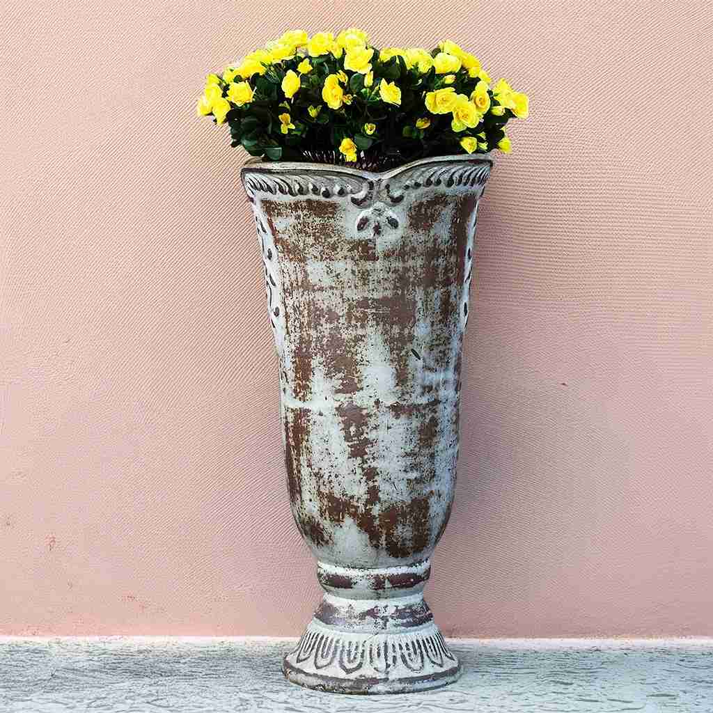 Distressed white pedestal vase planter featuring an embossed flower design and a vintage-inspired finish