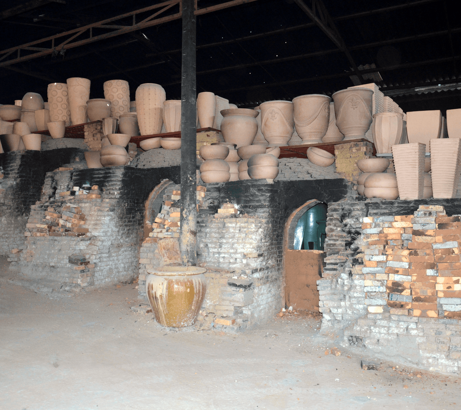 Stacked ceramic pots in various sizes neatly arranged on a warehouse