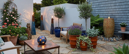 stylish outdoor garden or courtyard featuring a mix of ceramic planters, furniture, lighting, and water features