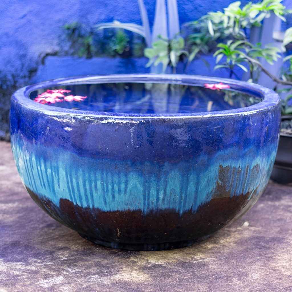 Wide round planter pot in blue and brown with a striking dripping glaze effect