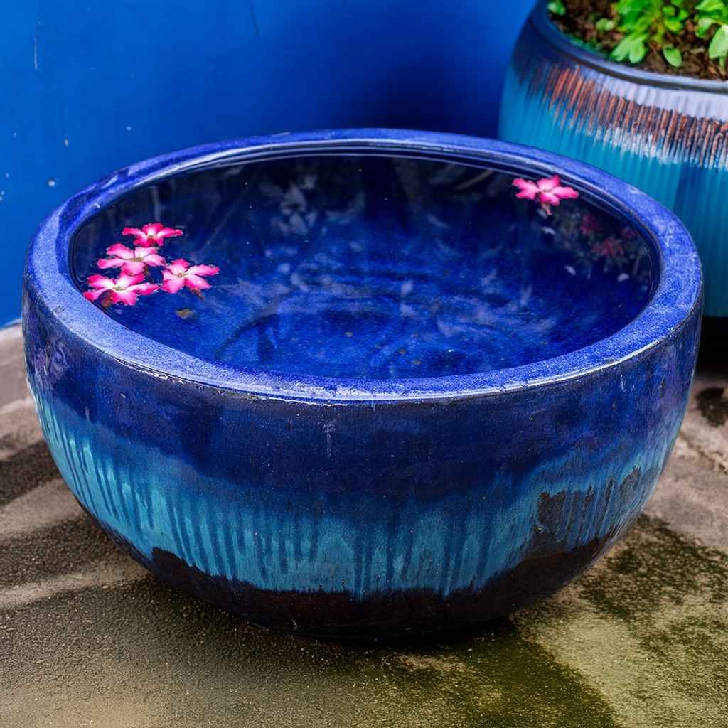 Wide round planter pot in blue and brown with a striking dripping glaze effect
