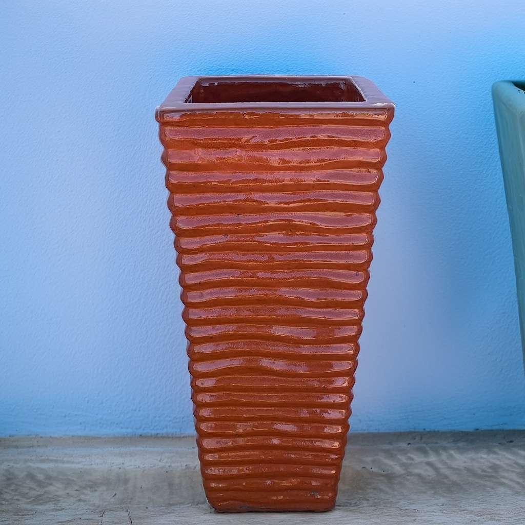 Tall, wavy ceramic planter in terracotta